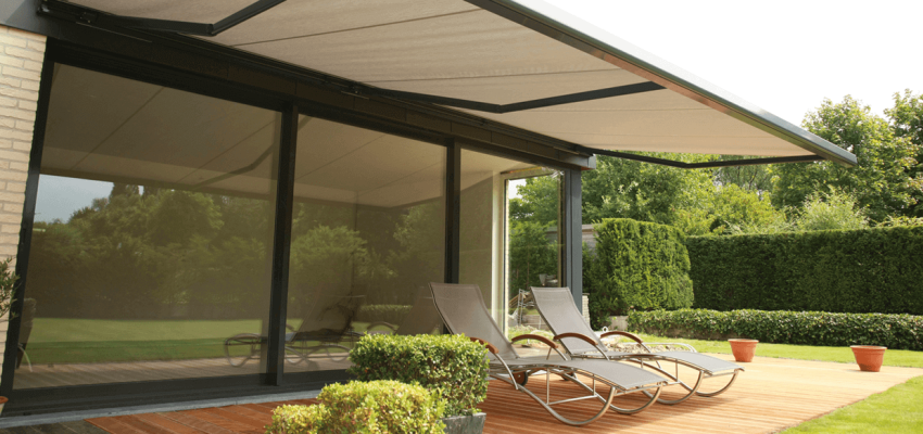 An awning outstretched over a pato with sun lounges